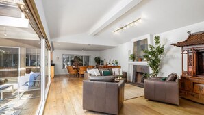 A spacious living area with a high ceiling, a fireplace, and a traditional wooden structure. - Carlsbad Zen - Large Pool (Carlsbad)