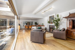 A spacious living area with a high ceiling, a fireplace, and a traditional wooden structure. - Carlsbad Zen - Large Pool (Carlsbad)