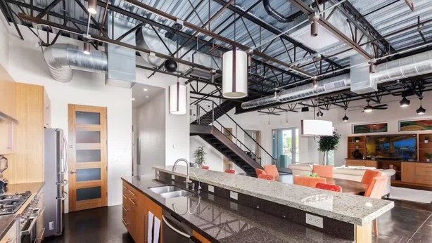A modern kitchen with a central island, stainless steel appliances, and a staircase leading to a living area. - Vantage - Rooftop Patio - Heart of Old Town (Scottsdale)