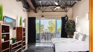 A modern bedroom with a large bed, a balcony with chairs, and a view of the outdoors. - Vantage - Rooftop Patio - Heart of Old Town (Scottsdale)