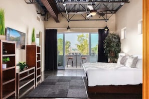 A modern bedroom with a large bed, a balcony with chairs, and a view of the outdoors. - Vantage - Rooftop Patio - Heart of Old Town (Scottsdale)