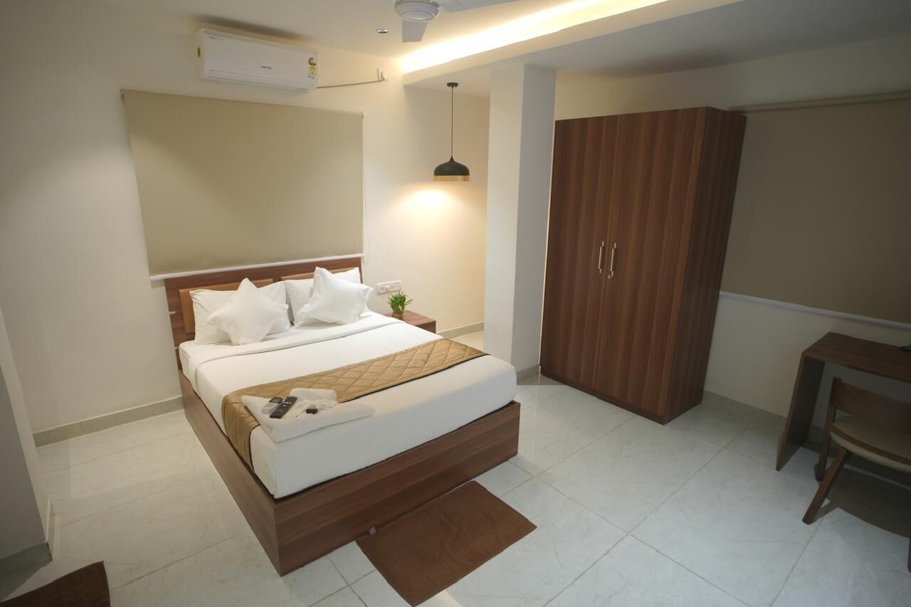 A modern bedroom with a bed, bedside table, wardrobe, and a desk.