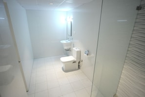 Ein modernes Badezimmer mit Toilette, Waschbecken und Spiegel.