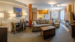 A modern living room with a sofa, coffee table, and dining area. - Cahilty #332 Hotel Room (Sun Peaks)