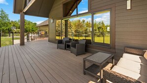 Eine überdachte Terrasse mit Korbmöbeln und einem Basketballkorb.