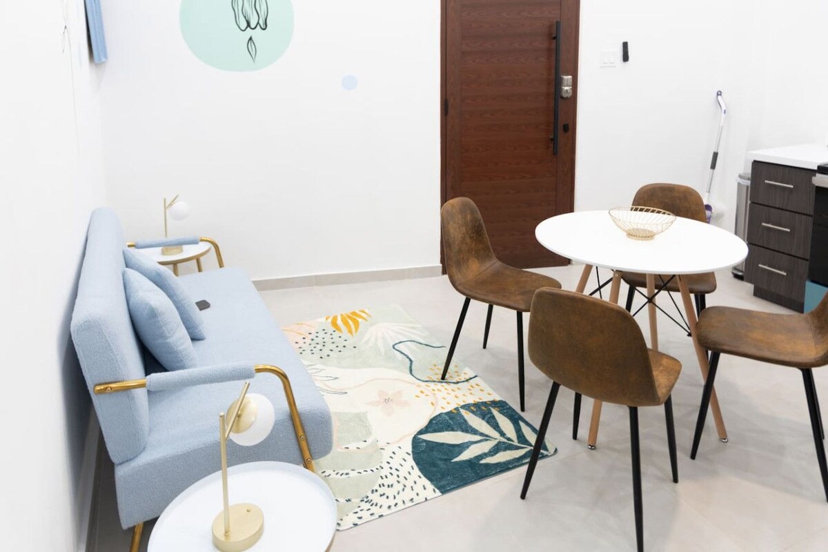 Een moderne woonkamer met een bank, stoelen, een salontafel en een vloerkleed.