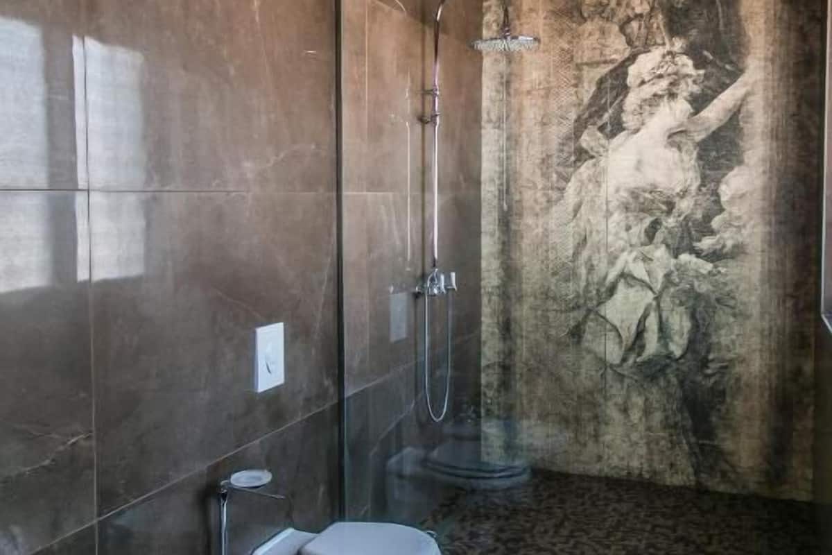 A bathroom with a shower, toilet, and bidet.