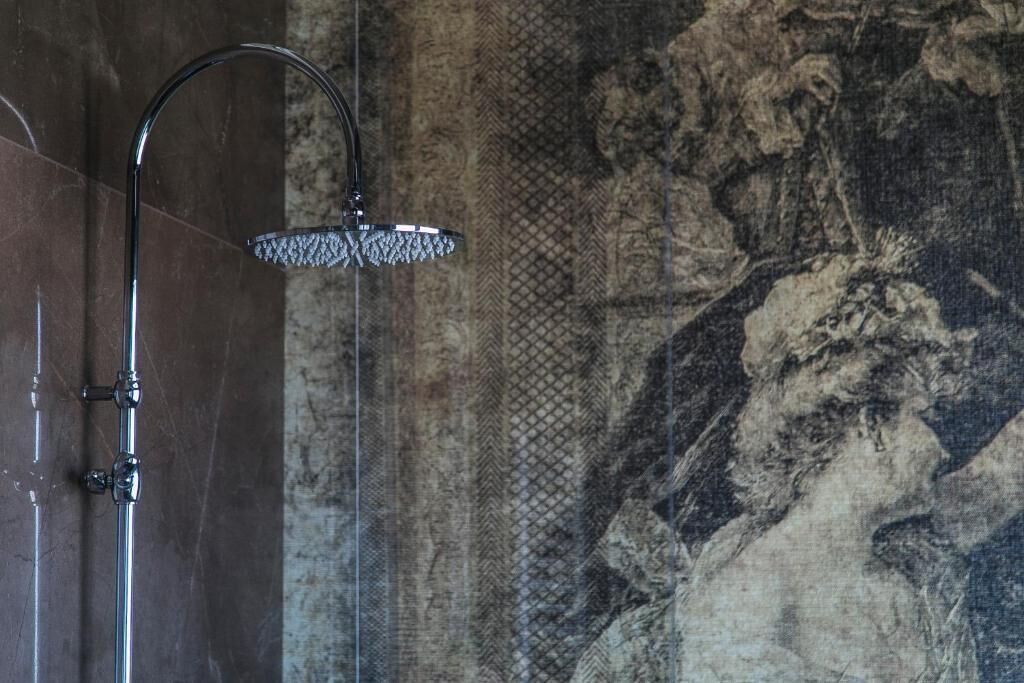 A shower with a curved head and a handheld showerhead.