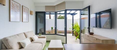 A modern living room with a sofa, coffee table, and a TV mounted on the wall.