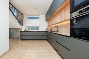 Una cocina moderna con horno integrado, microondas y cafetera.