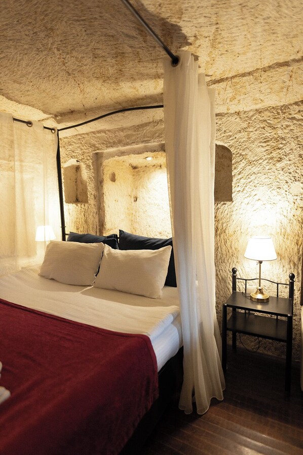 Une chambre avec un lit, une table de chevet et une lampe.
