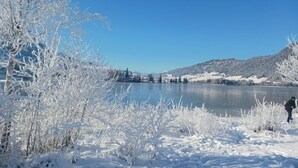 Paesaggio innevato con un lago e montagne sullo sfondo.