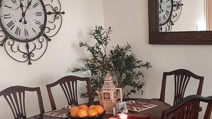 A dining area with a round table, six chairs, a decorative clock, a mirror, and a small plant. - The Parkview House Wakefield - 31 Tuke Grove not 42 Please (Wakefield)