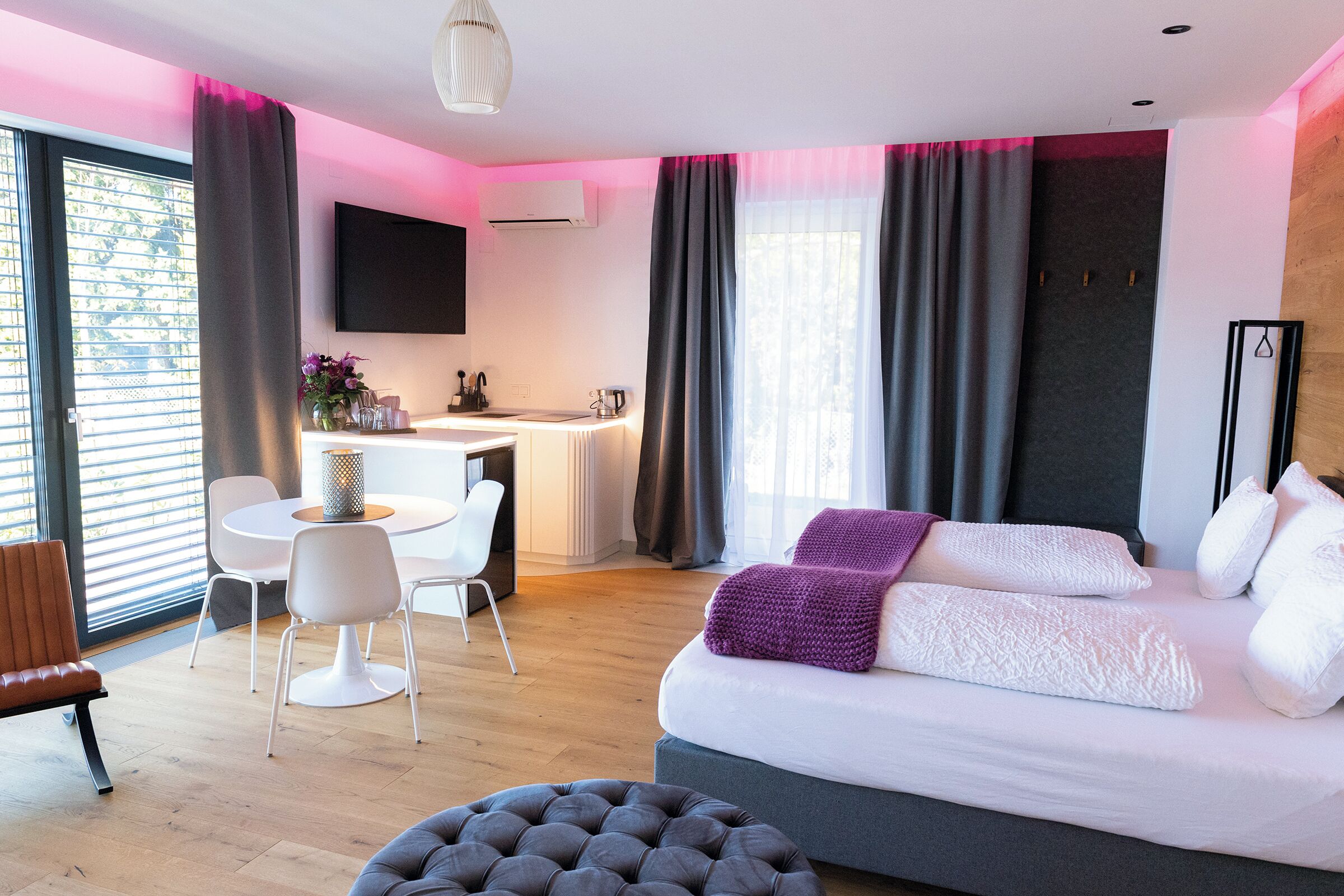Una moderna camera d'albergo con un letto grande, una scrivania e un'area pranzo.