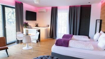 Una moderna camera d'albergo con un letto grande, una scrivania e un'area pranzo.