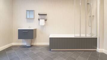 Une salle de bain moderne avec un meuble-lavabo gris, une baignoire et une douche à parois de verre.