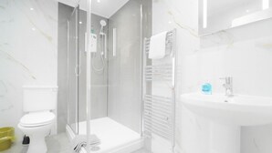 Ein modernes Badezimmer mit Duschkabine, Toilette und Waschbecken.