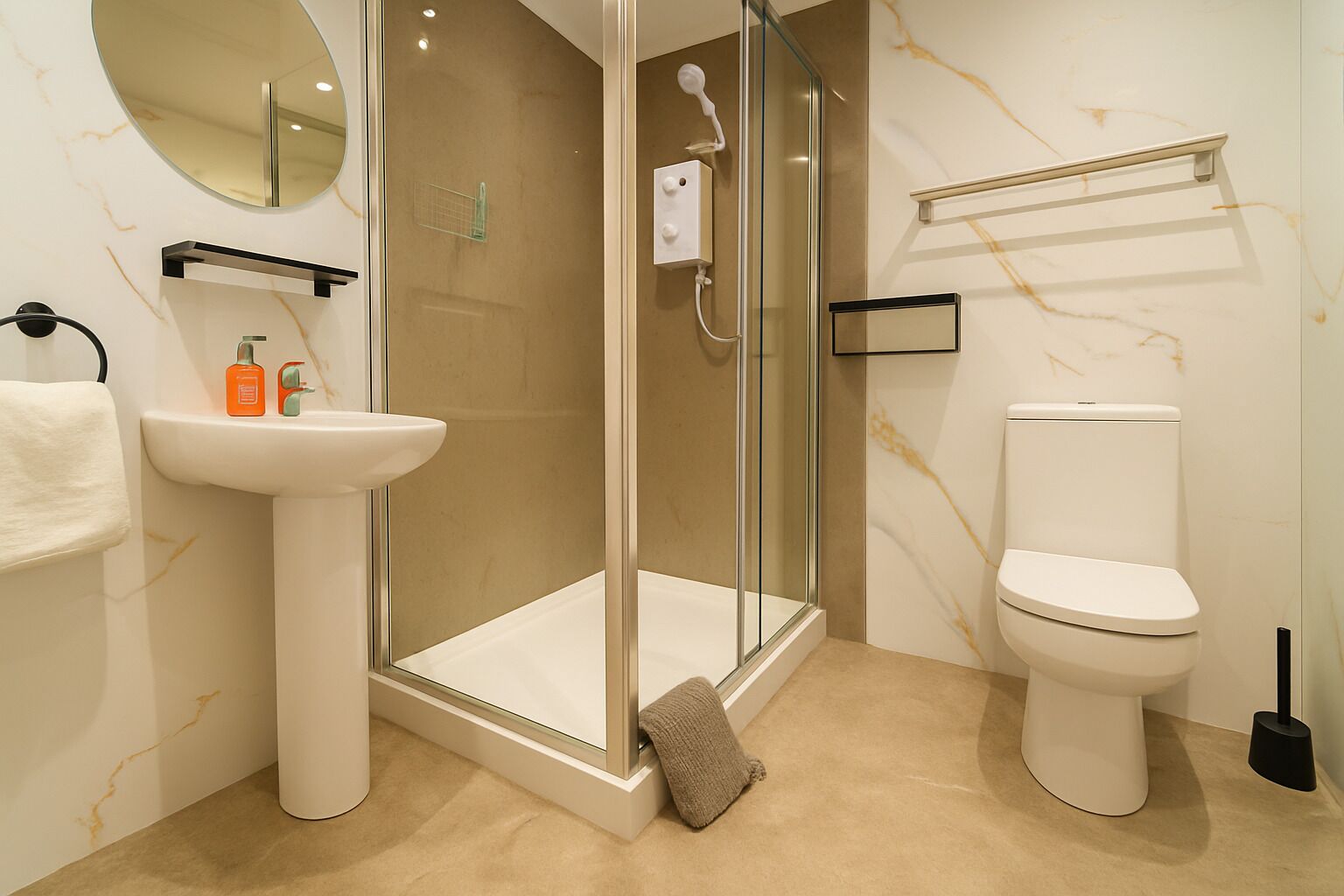 Un baño moderno con ducha de vidrio, lavamanos blanco y retrete.