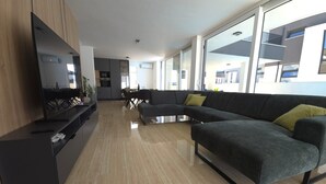 Una sala de estar moderna con un sofá modular gris oscuro, un televisor de pantalla plana y un mueble de madera.