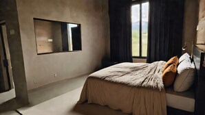 Un dormitorio con cama, ventana con cortinas, espejo y vistas al exterior.