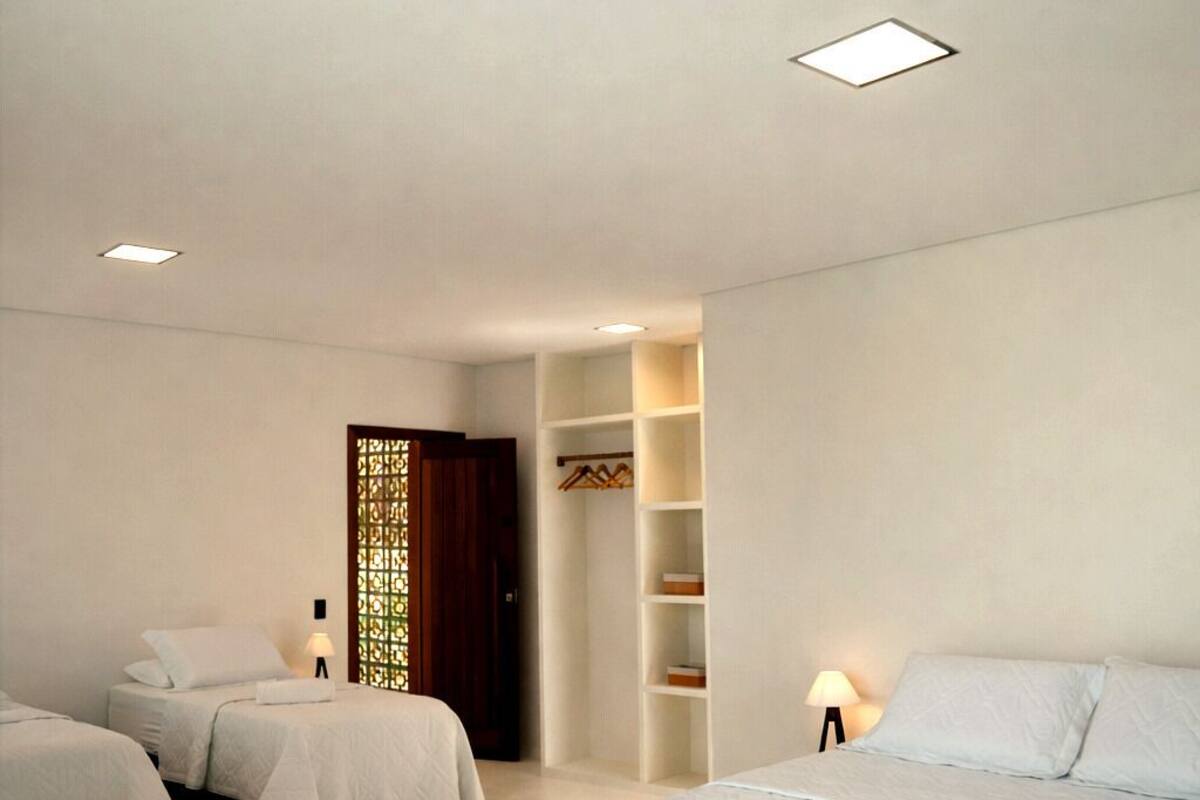 Habitació d'hotel amb dos llits, un armari, una zona de seients petita i un panell decoratiu.