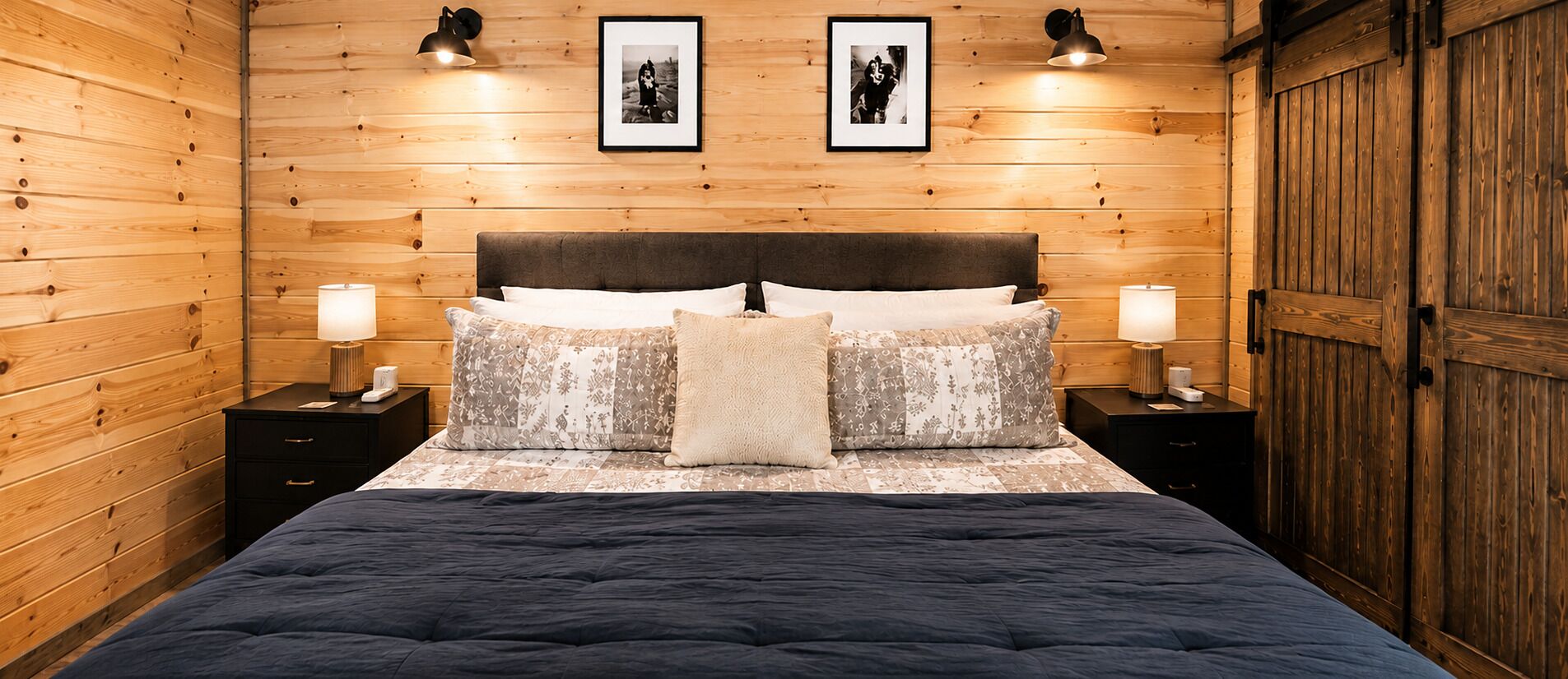 Ein Zimmer mit Holzwänden, einem Bett, zwei Nachttischen und einem Kleiderschrank.