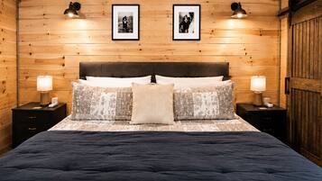 Ein Zimmer mit Holzwänden, einem Bett, zwei Nachttischen und einem Kleiderschrank.