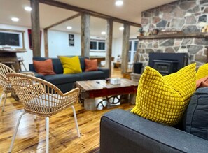 A cozy living room with a sofa, chairs, and a coffee table. - Waterfront Nature Escape • Hot Tub (Tay Valley)