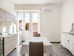 Eine kleine Küche mit Essbereich, ein Fenster mit Blick und eine weiße Klimaanlage.