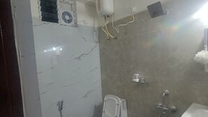 Une salle de bain avec des toilettes, une douche et un lavabo.