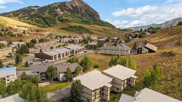 Zona residencial con varios edificios de apartamentos, una montaña destacada al fondo y un cielo despejado.