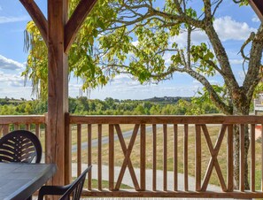 Eine Holzterrasse mit Blick auf eine Straße und Grünflächen.