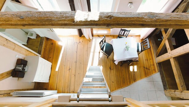 A wooden interior with a staircase leading to a dining area. - Apartment 5 - Abendträumerei - Holiday apartment with loft in the count's forester's lodge (Temmen-Ringenwalde)