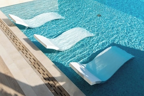 Ein klares, blaues Schwimmbecken mit drei weißen, schwimmenden Absperrungen.