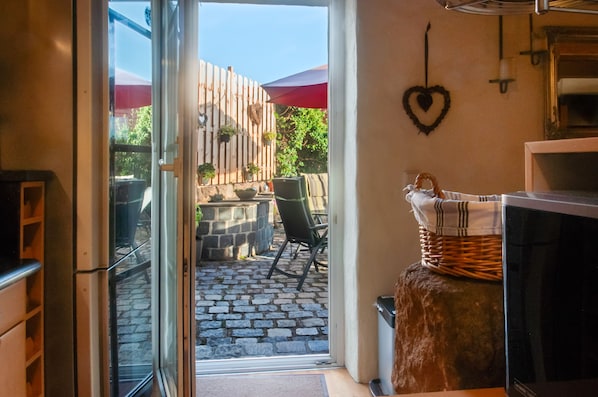 A kitchen with a stone countertop, a wicker basket, and a heart-shaped decoration on the wall.