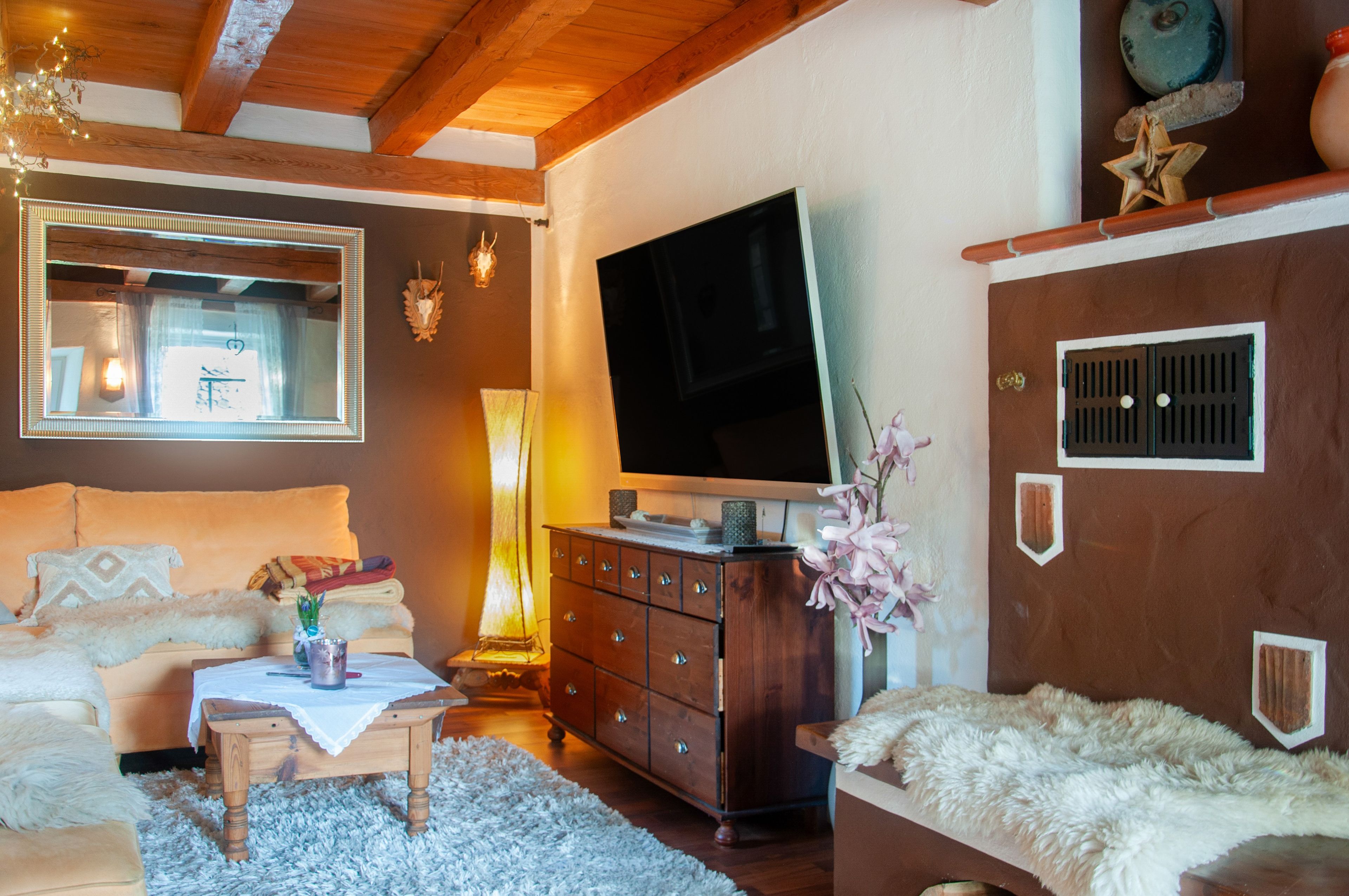 A cozy living room with a sofa, a coffee table, a TV, and a fireplace.