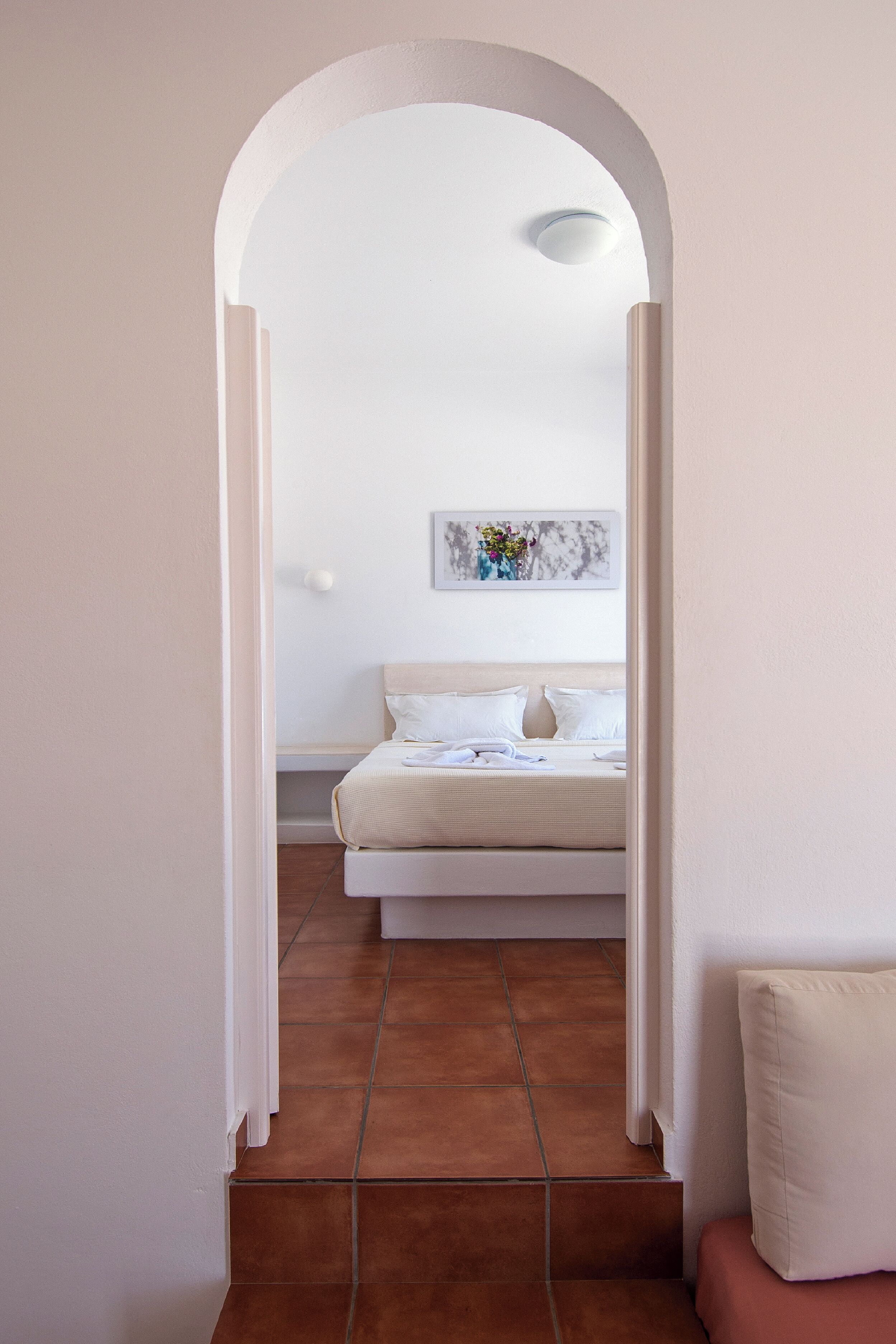 A bedroom with a bed, a nightstand, and a wall-mounted artwork.