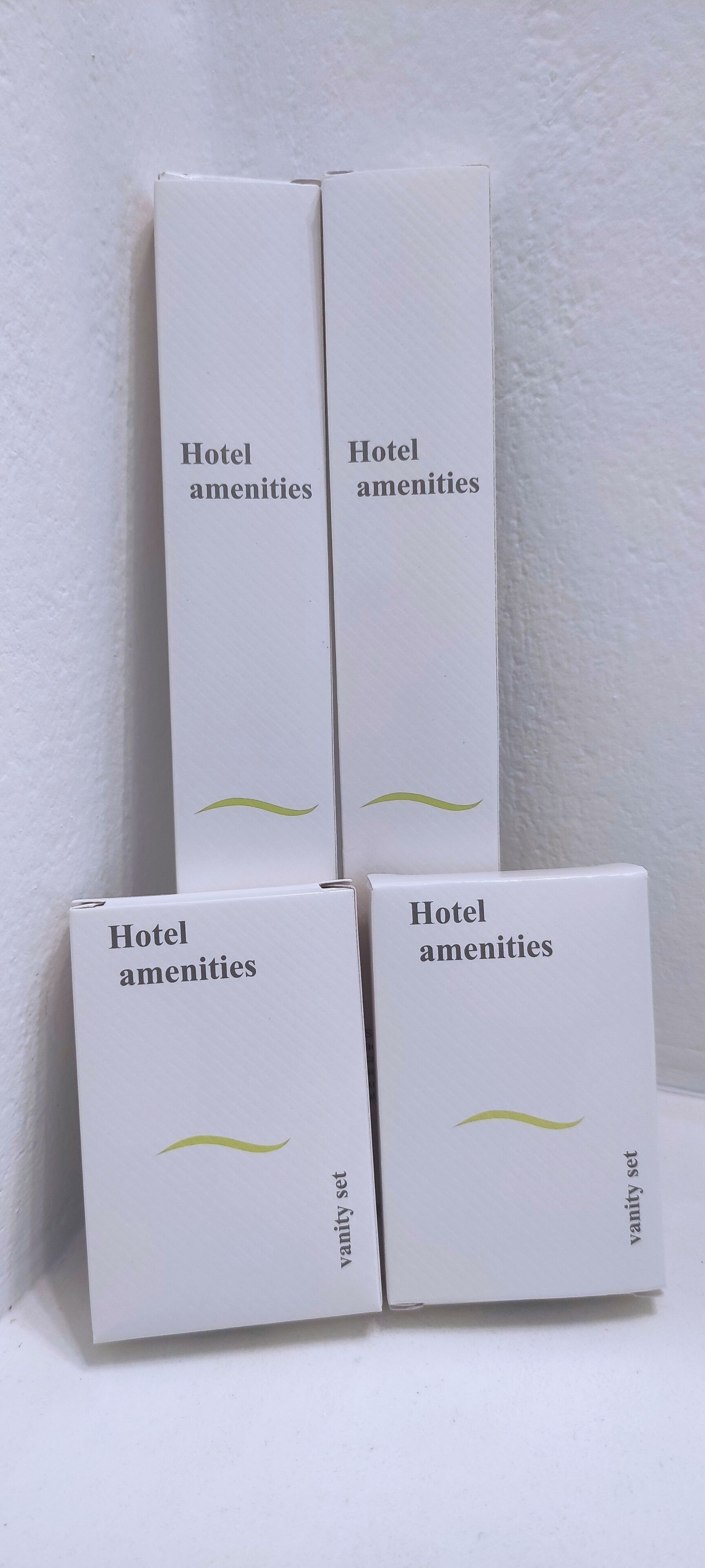 Cuatro cajas blancas con los rótulos 'Servicios del hotel' y 'kit de tocador' sobre un fondo blanco.