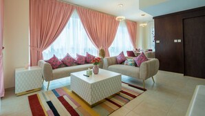A modern living room with a sofa set, a coffee table, and a patterned rug. - ina Homes - 1 BHK Tower 5 (Dubai)