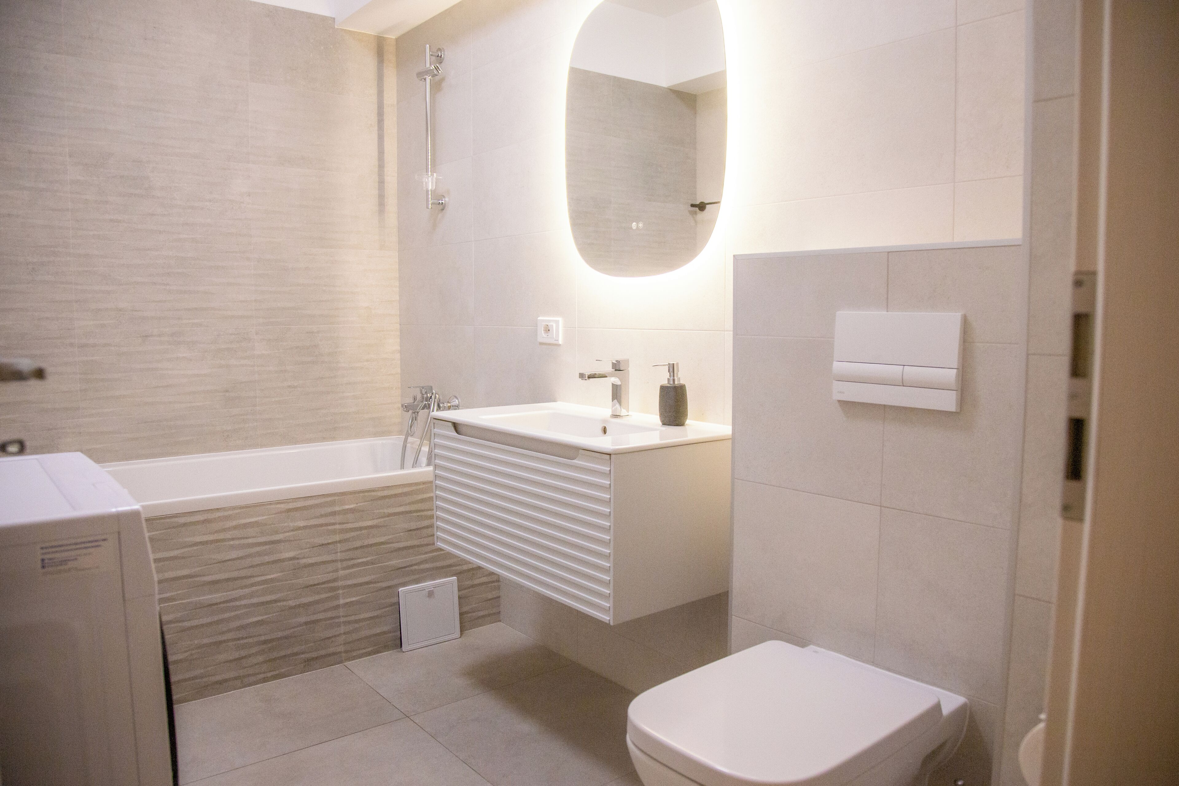 Un baño moderno con bañera, lavamanos e inodoro.
