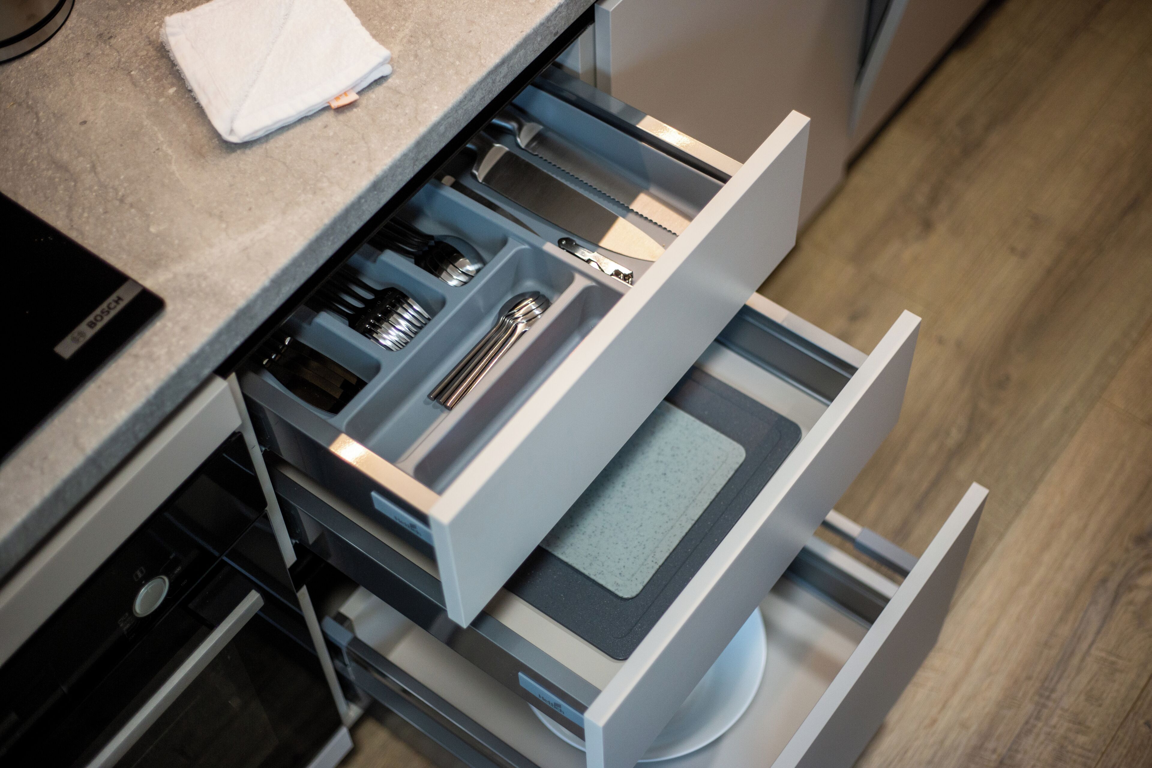 A kitchen drawer with utensils and a Bosch appliance.