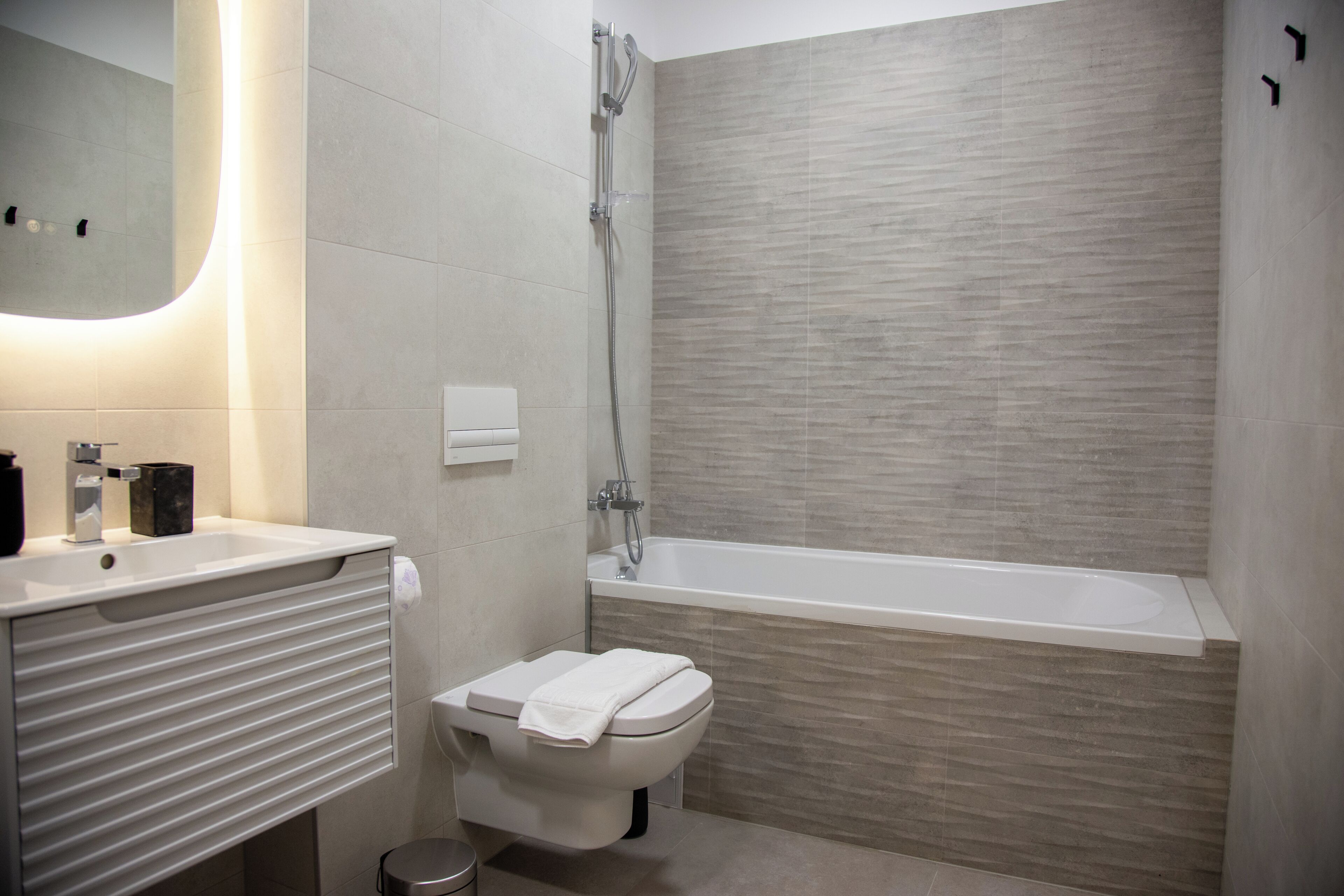 A modern bathroom with a toilet, sink, and bathtub.