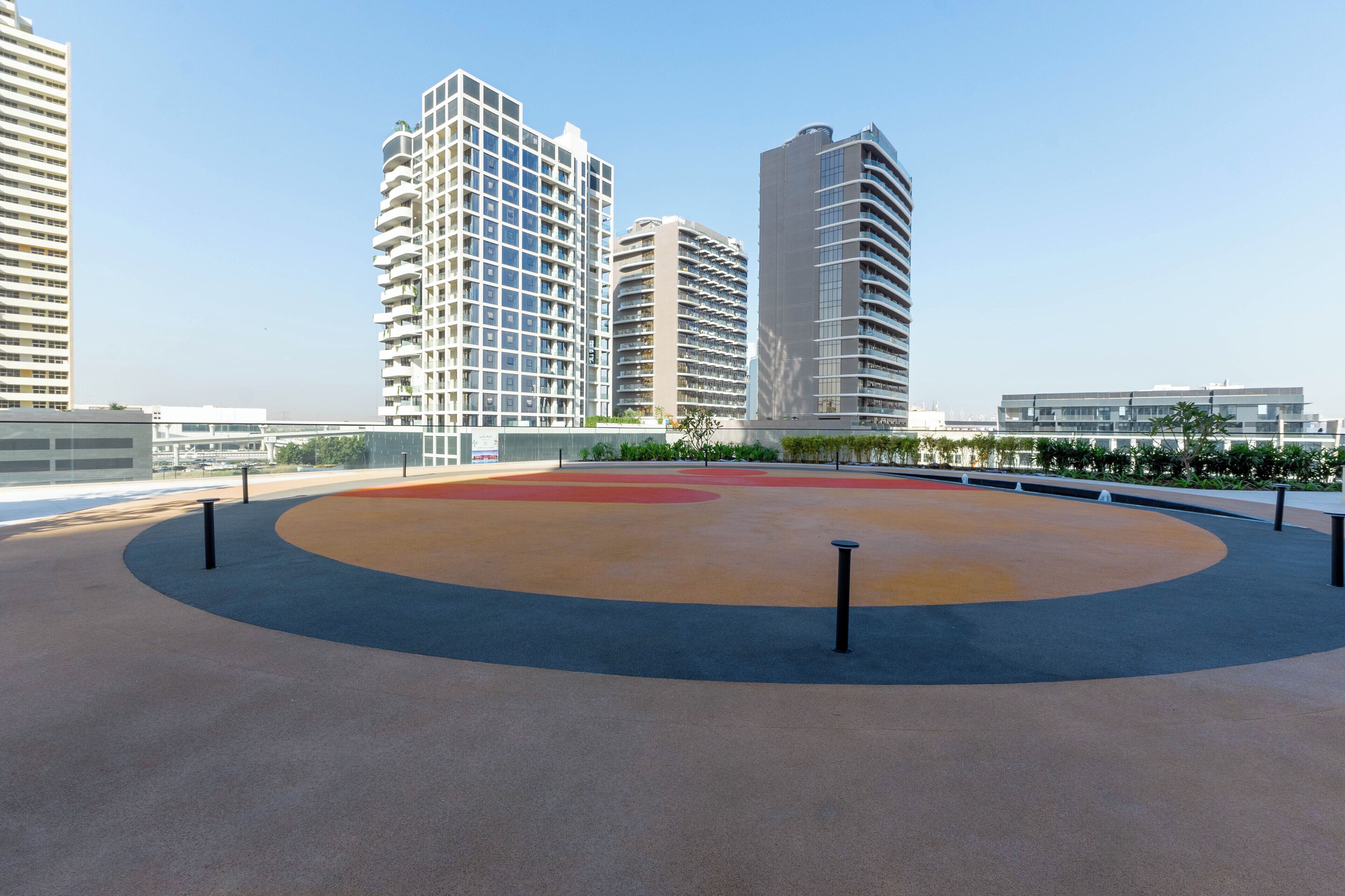 Un espace de jeux avec une piste circulaire et des bâtiments environnants.