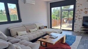Een moderne woonkamer met een hoekbank, een salontafel en een televisie.