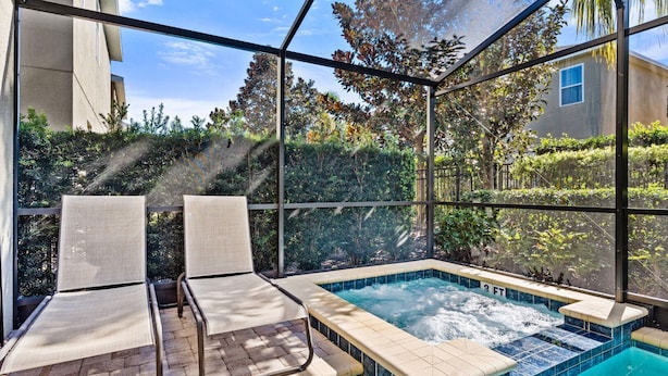 An indoor swimming pool with two lounge chairs and a glass enclosure. - 25% Off 8BR Villa! Private Pool & Spa (Kissimmee)