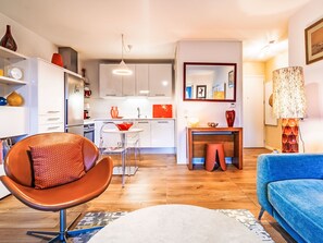 A modern living room with a brown leather chair, a blue sofa, and a wooden floor. - Apartment Xarako by Interhome (Urrugne)