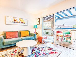 A living room with a sofa, a coffee table, and colorful chairs. - Apartment Xarako by Interhome (Urrugne)