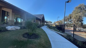 A building with a covered walkway, a small tree, and a fence. - Large 5-Bedroom Georgetown Getaway/Minutes to Blue Hole Park + Historic Square (Georgetown)
