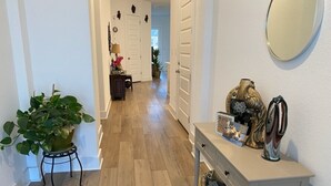 A hallway with a potted plant, a console table with decorative items, and a patterned rug. - Large 5-Bedroom Georgetown Getaway/Minutes to Blue Hole Park + Historic Square (Georgetown)