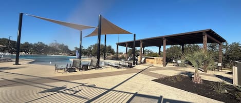 Un espace aménagé au bord de la piscine, doté de parasols, de chaises longues et d’un coin salon abrité.
